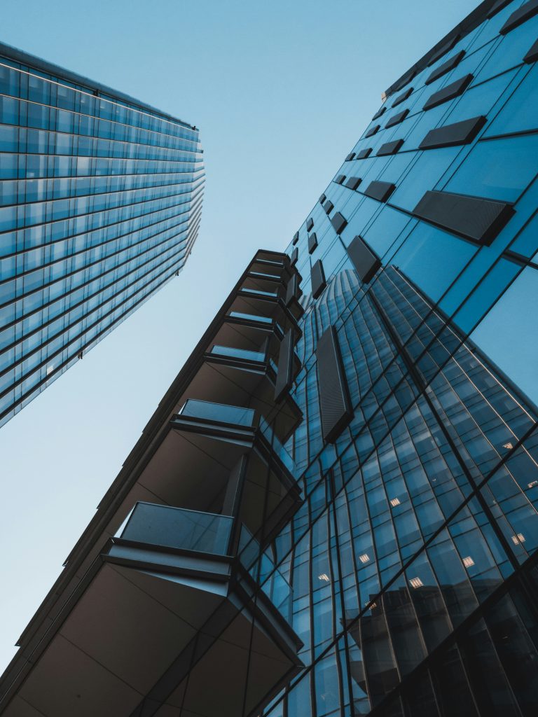 Upward view of tall glass office buildings against the sky.